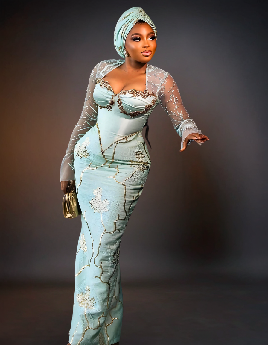 Luxurious Long Sleeve Aso Ebi Dress in Mint Green. The dress features elegant, intricate lace detailing and a fitted silhouette, showcasing a blend of traditional and modern design elements.