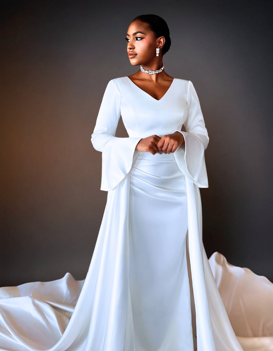 A luxury satin mermaid wedding dress. The dress features long sleeves and a fitted silhouette that flares out at the bottom.