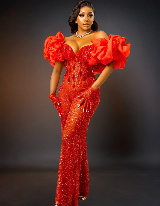  luxurious red jumpsuit designed for prom. It features intricate sequin lace detailing, adding a touch of sparkle and elegance. 