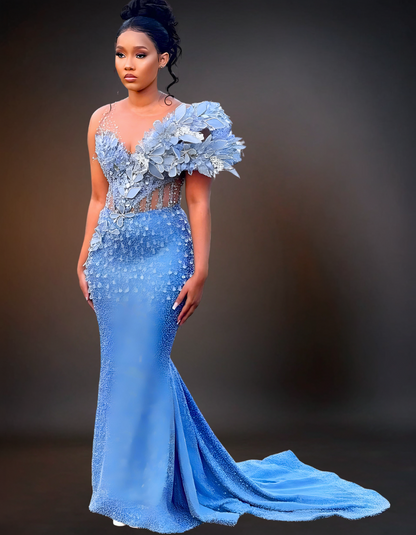 A stunning luxury long prom dress in a beautiful shade of blue, adorned with intricate pearl detailing. The gown features a fitted bodice and a flowing skirt, creating an elegant and sophisticated look perfect for special occasions.