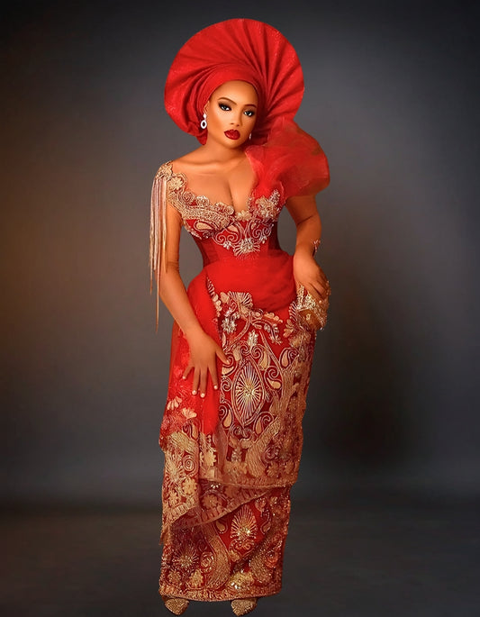 Luxury traditional George lace wedding attire in gold and red. The outfit features intricate gold embroidery on a rich red fabric, showcasing a blend of elegance and cultural heritage, perfect for a wedding ceremony.