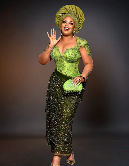 luxurious traditional African wedding attire, known as Aso Ebi. The outfit is a rich green color, featuring intricate gold embroidery and embellishments. 