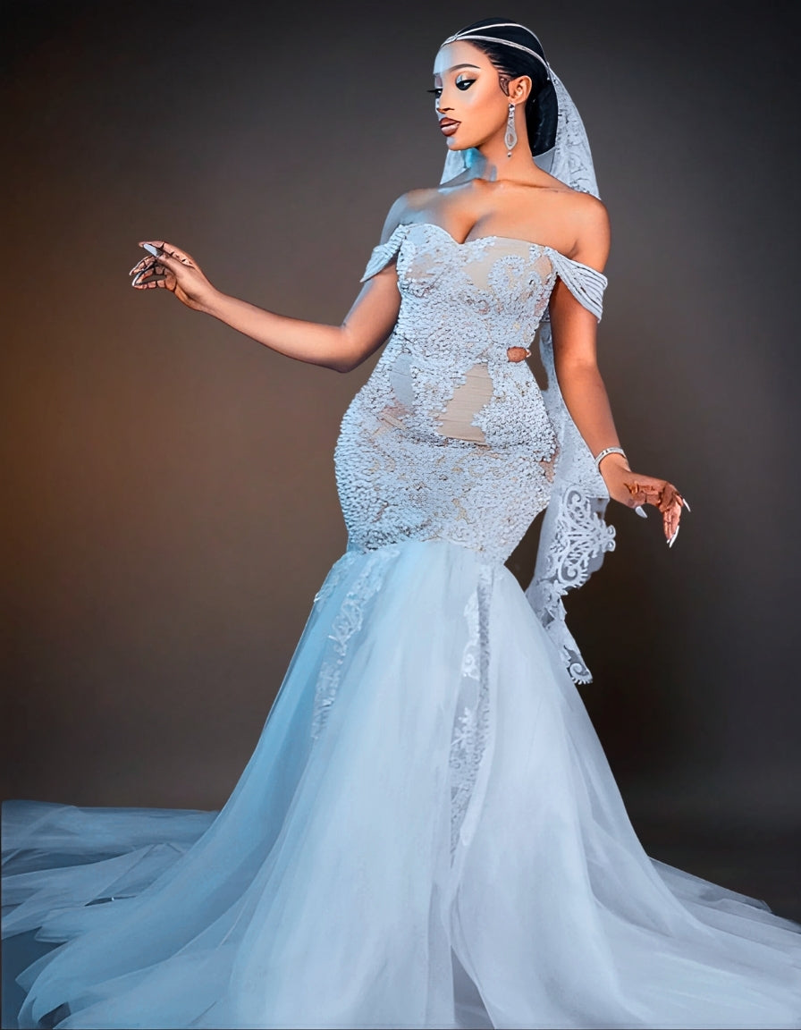 An elegant white wedding dress adorned with intricate beadwork. The gown features a fitted bodice and a flowing skirt, shimmering with delicate, shiny beads that add a touch of luxury and sophistication.