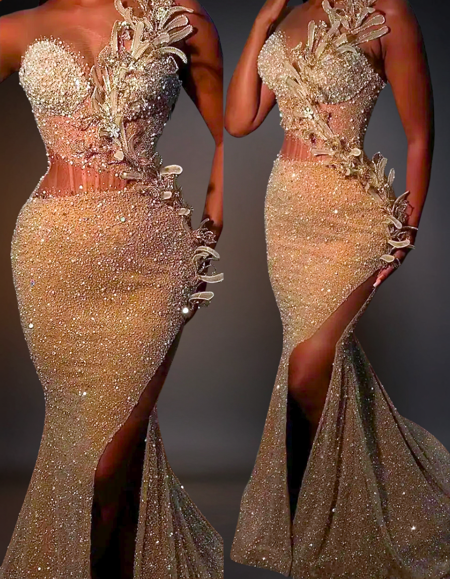 Elegant gold evening gown with intricate detailing on a blurred background