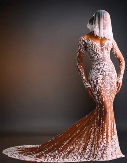 Woman wearing a white lace dress with a long train against a dark background