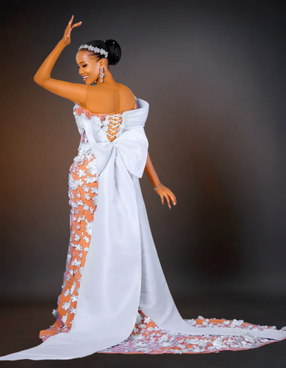 Woman in a white and orange dress with floral details against a dark background