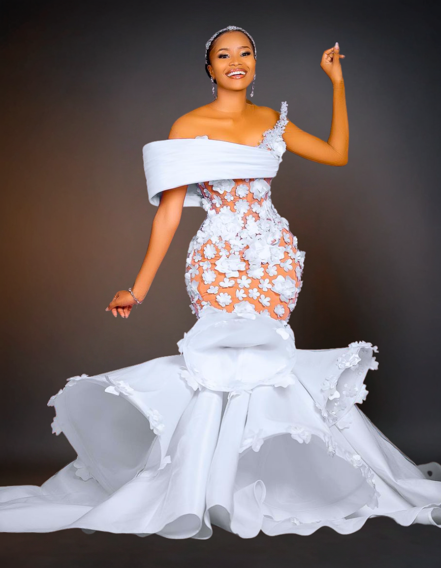 Woman in a white and orange floral dress against a dark background