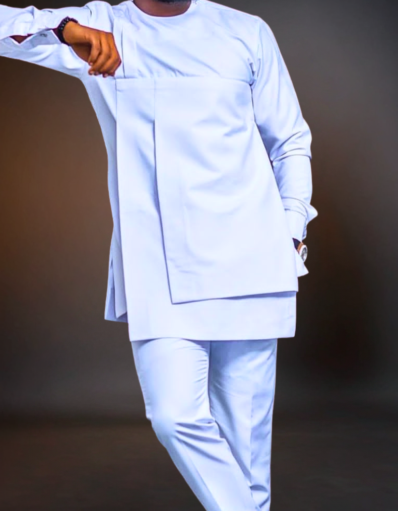 Man wearing a light blue traditional outfit against a dark background