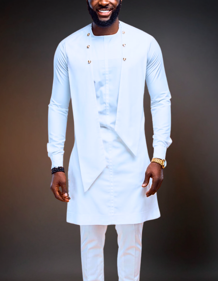 Man wearing a light blue traditional outfit with white pants against a dark background